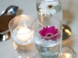 a simple cluster centerpiece that consists of glasses with blooms