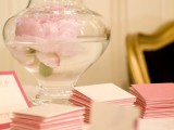a large vase with a pink peony floating inside is a lovely idea for any wedding and won’t break the bank