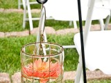 a chic jar with a floating coral bloom is a beautiful decoration for a wedding aisle, it won’t require much effort or money
