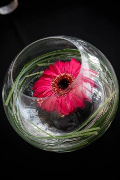a glass bowl with a bold bloom and grass is a lovely idea to make the space bolder and cooler