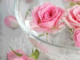 a bowl with floating pink roses is a lovely centerpiece or decoration for a wedding and it looks cool and fresh
