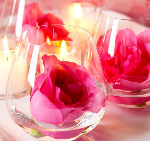Wine glasses with floating bold pink roses are lovely for stylish wedding decor and can be used anywhere