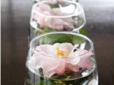 large wine glasses with floating pink peonies are lovely decorations for spring or summer weddings