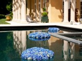 a pool decorated with floating blue hydrangeas is a lovely idea for an outdoor or pool wedding