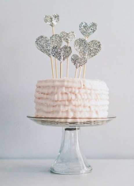 a blush ruffle wedding cake topped with silver glitter hearts is a tender and sweet idea for Valentine's Day