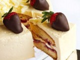 a neutral wedding cake topped with strawberries in chocolate is great for Valentine’s Day