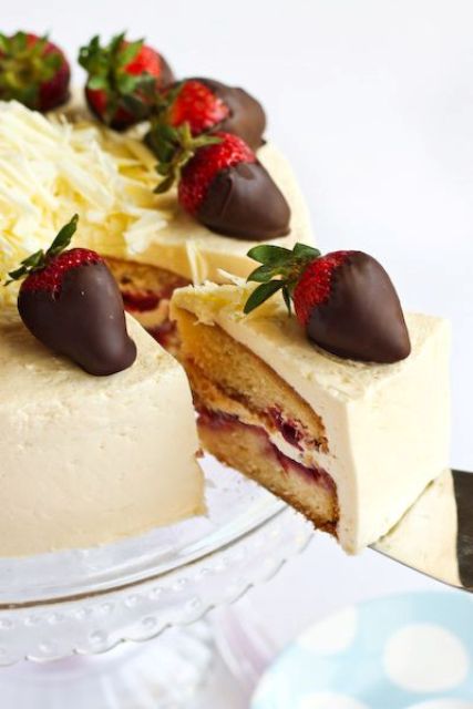 a neutral wedding cake topped with strawberries in chocolate is great for Valentine's Day