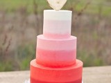 an ombre white to pink and red wedding cake with a heart topper is a great idea for a modern Valentine wedding