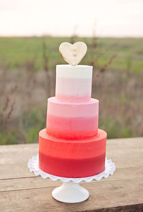 an ombre white to pink and red wedding cake with a heart topper is a great idea for a modern Valentine wedding