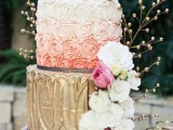 a whimsical wedding cake with gold, ombre pink and a chevron one, decorated with fresh blooms, gilded berries on branches is a beautiful dessert