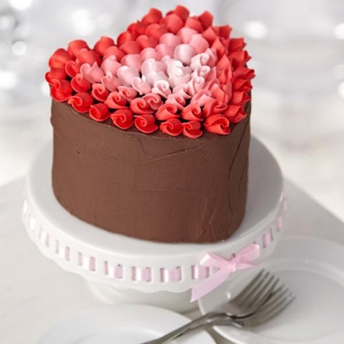 a chocolate heart-shaped wedding cake topped with red and pink cream looks beautiful and gorgeous