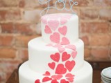 a modern and bold white wedding cake decorated with ombre hearts and a wire topper is a lovely and bold idea