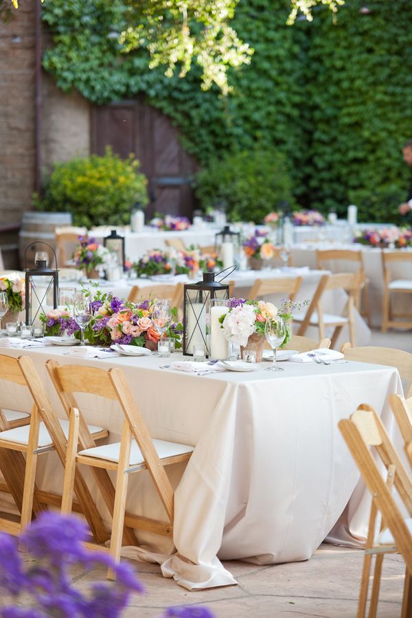 Bright floral arrangements paired with candle lanterns are great centerpieces for many weddings, not only vineyard ones