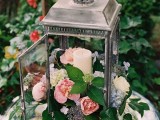 a stylish vineyard wedding centerpiece – a candle lantern filled with pink and coral blooms and greenery