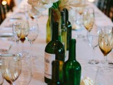 a catchy vineyard wedding centerpiece of wine and beer bottles and white tulips in them is a bold idea