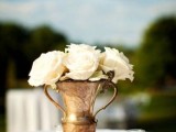 a vintage vase with white roses is a romantic and chic centerpiece that will fit not only a vineyard but many other weddings, too