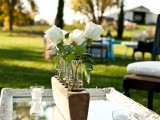 a mirror tray, a wooden stand with tubes and white roses for a stylish wedding centerpiece