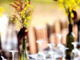 bright fall vineyard wedding centerpieces of mustard and burgundy blooms plus berries look cool