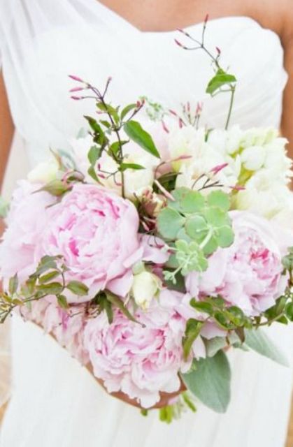 a spring wedding bouquet with light pink and white blooms and greenery is a season embracing one