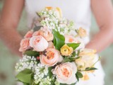 a pastel wedding bouquet with blush peonies, yellow and white blooms and greenery