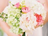 a cute spring wedding bouquet with blush, pink and greenery blooms is ideal for a spring bride