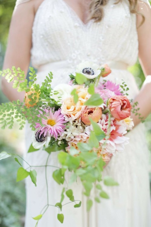 a colorful spring wedding bouquet with red, pink, yellow flowers and greenery for more texture