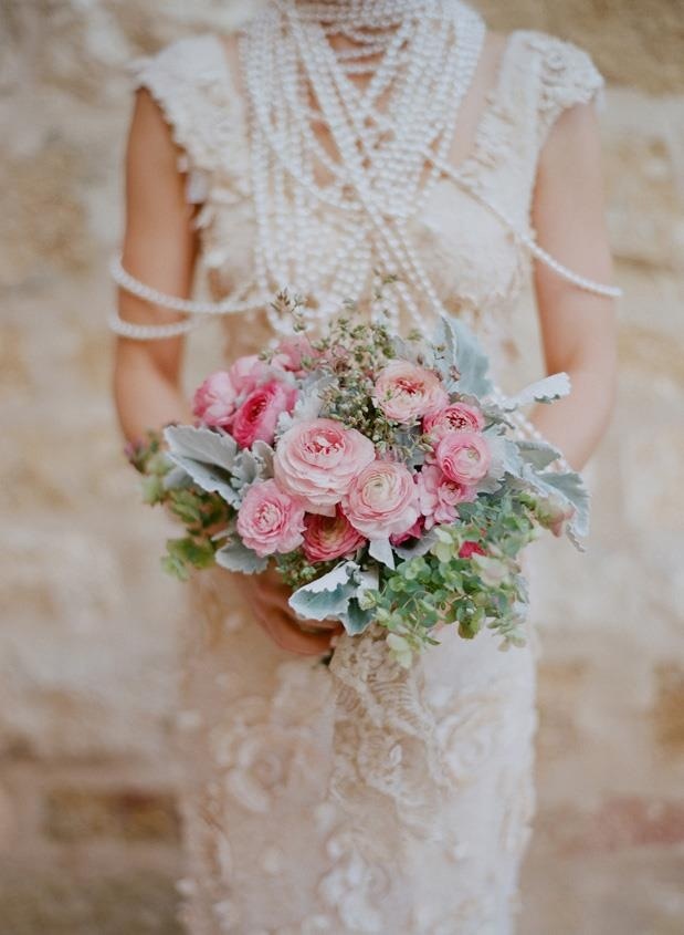 a spring wedding bouquet with pink blooms and pale greenery and some blooming branches for a texture