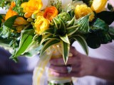 a colorful spring wedding bouquet in marigold and white, with plenty of foliage for a texture