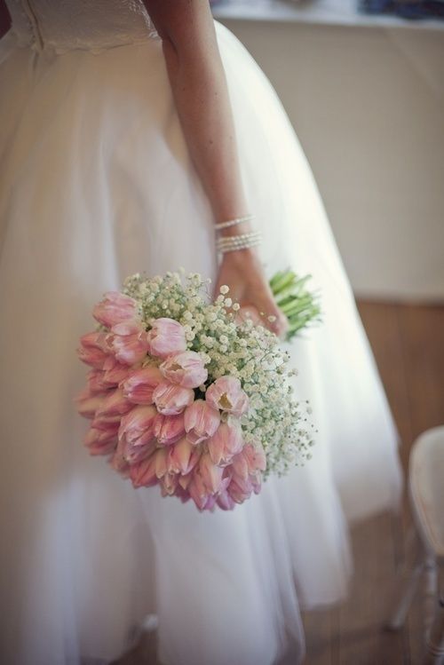 a classic wedding bouquet of pink tulips and baby's breath is a romantic idea for a spring bride