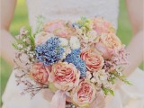 a spring wedding bouquet of peachy blooms, some blues and blooming branches for a romantic feel