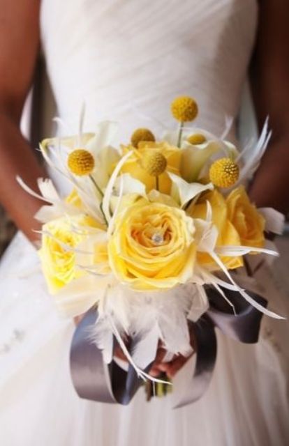 a yellow and white wedding bouquet with craspedia, roses and some feathers is a bold and cool idea