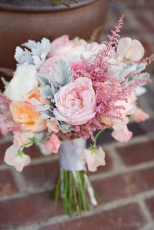 a chic and romantic spring wedding bouquet with pink and peachy blooms, pale millet and white touches