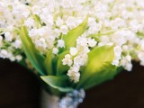 a chic and aromatic lily of the valley wedding bouquet with an elegant wrap for a spring bride
