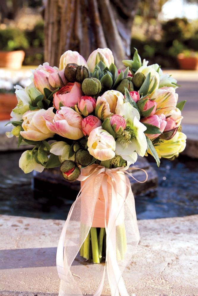 a bright spring wedding bouquet with pink and blush blooms and some blush ribbons for a spring bride