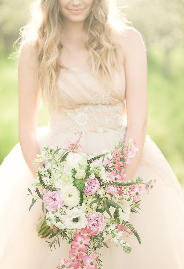 a romantic wedding bouquet of white and light pink blooms, with plenty of texture and greenery