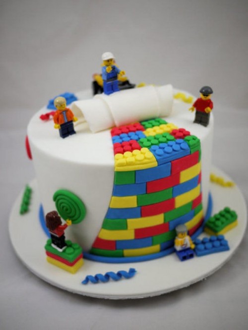 a white wedding cake with colorful LEGO details of sugar and fun LEGO people of sugar is a perfect idea for a groom's cake