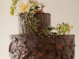 a tree stump wedding cake topped with white blooms and greenery is a great idea for a rustic party, and it can fit a hiker or hunter