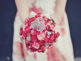 a red brooch and button wedding bouquet of buttons is a bright and cool idea that you can DIY