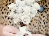 a small wedding bouquet composed of book page flowers and with a lace wrap is a pretty and delicate idea, take the book that matters a lot