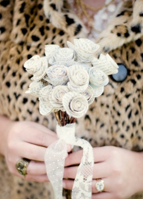 a small wedding bouquet composed of book page flowers and with a lace wrap is a pretty and delicate idea, take the book that matters a lot