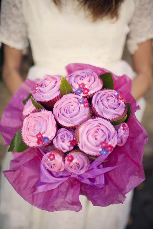 A purple cupcake wedding bouquet with some foliage and in a purple wrap is a very bold and cool idea for a sweet tooth