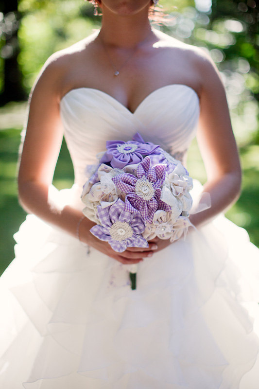 A pretty purple plaid and white fabric flower wedding bouquet with buttons and burlap is a fun idea for a summer bride