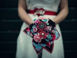 a colorful wedding bouquet of fabric, brooches and yarn balls in blue, red, pink and black is a very creative idea to rock