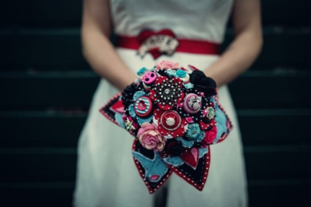 A colorful wedding bouquet of fabric, brooches and yarn balls in blue, red, pink and black is a very creative idea to rock