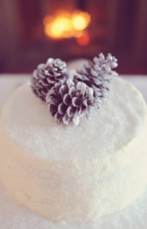 A sparkling white wedding cake topped with pinecones is a lovely idea for a winter wedding