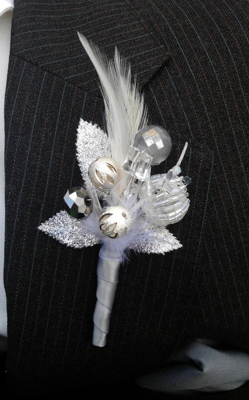 a sparkling silver/white wedding boutonniere composed of white beads, sparkling leaves imitates a floral piece