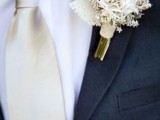 a neutral rustic boutonniere with burlap, a fabric bloom and dried herbs is an easy way to highlight the theme of the wedding