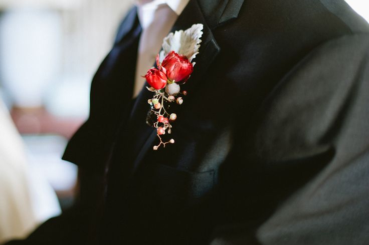 A winter boutonniere of a pale leaf, red blooms, berries will bring a touch of color to the look