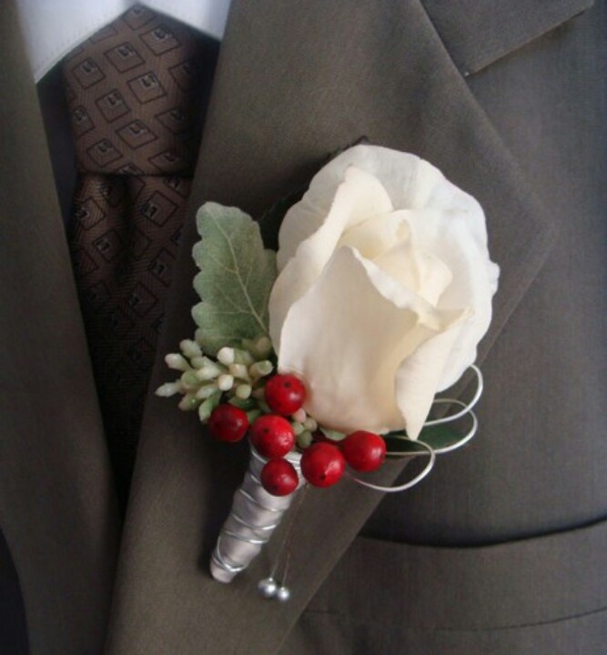 A white rose, pale leaves, berries boutonniere is a cute accessory for a winter groom