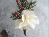 a winter wedding boutonniere of a white bloom, berries and fir branches is a cool and simple idea